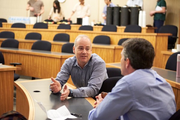 Two men talking in a lecture hall